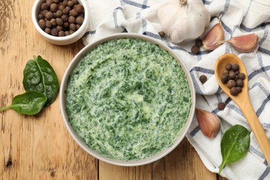 Photo of Delicious spinach sauce served on wooden table, flat lay