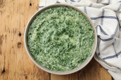 Photo of Delicious spinach sauce on wooden table, top view