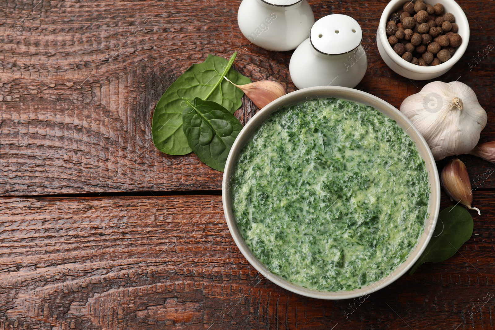 Photo of Delicious spinach sauce served on wooden table, flat lay. Space for text