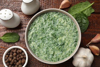 Photo of Delicious spinach sauce served on wooden table, flat lay