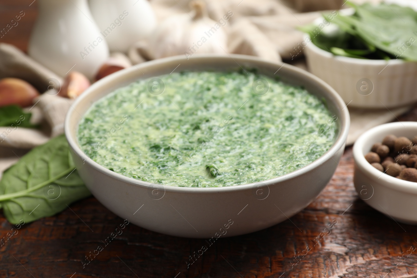 Photo of Delicious spinach sauce served on wooden table, closeup