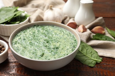 Delicious spinach sauce served on wooden table, closeup