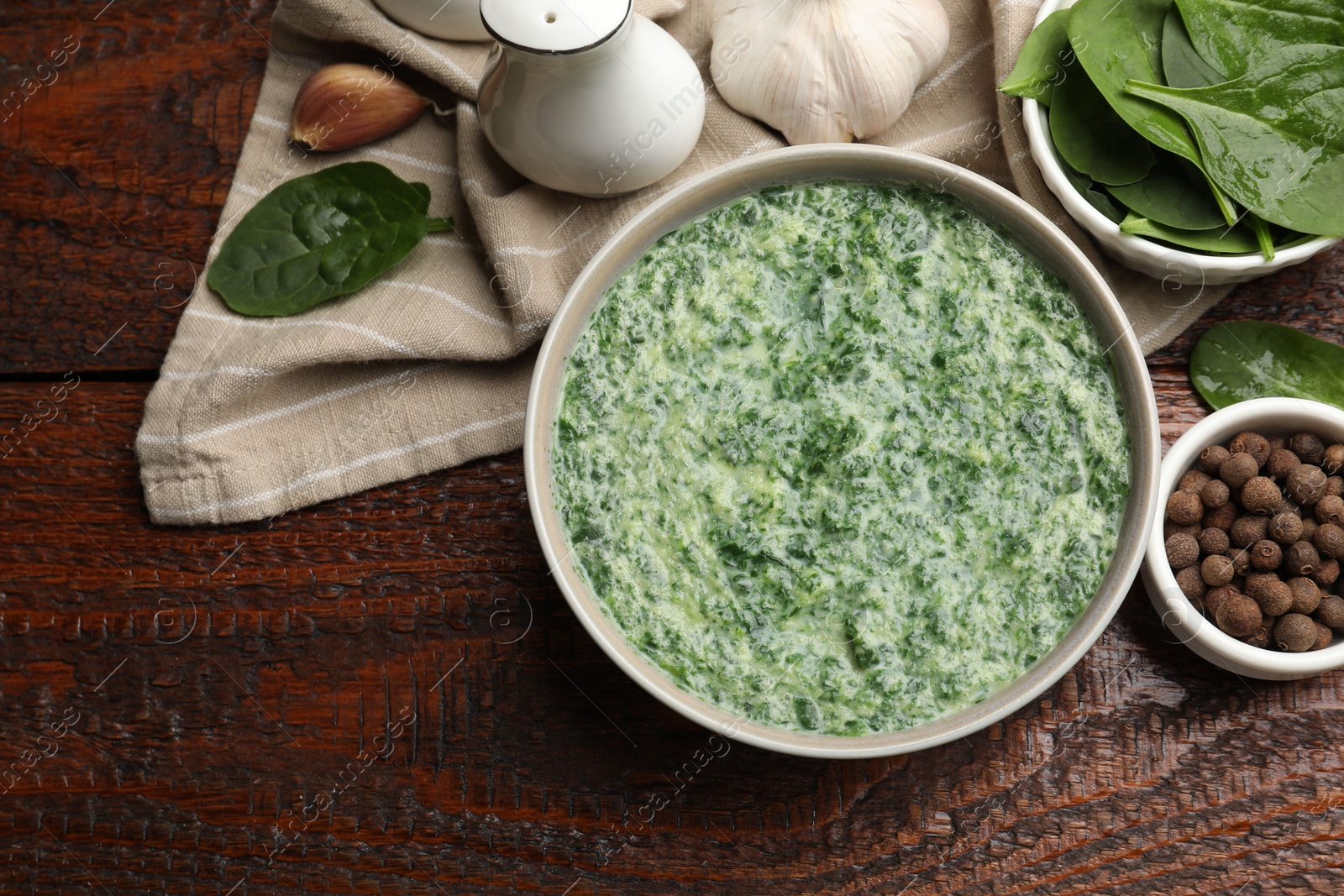 Photo of Delicious spinach sauce served on wooden table, flat lay