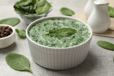 Delicious spinach sauce served on grey table, closeup