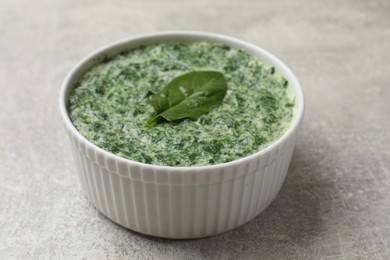 Photo of Delicious spinach sauce on grey table, closeup