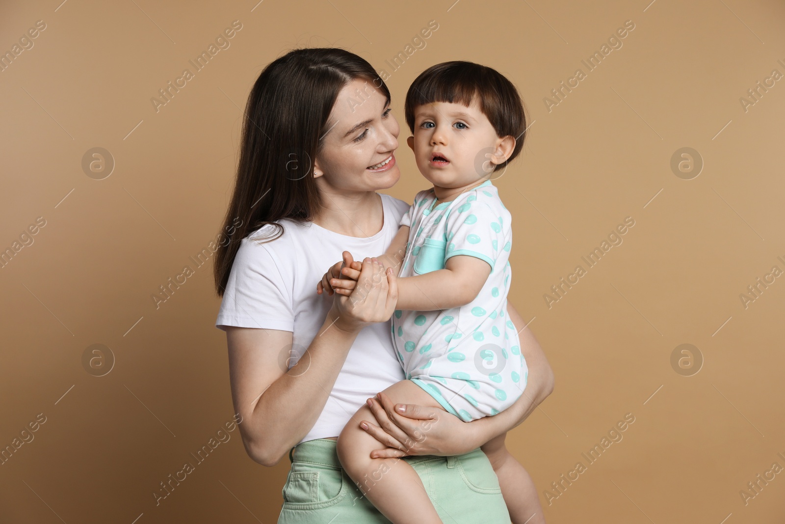 Photo of Family portrait of happy mother with her little son on beige background