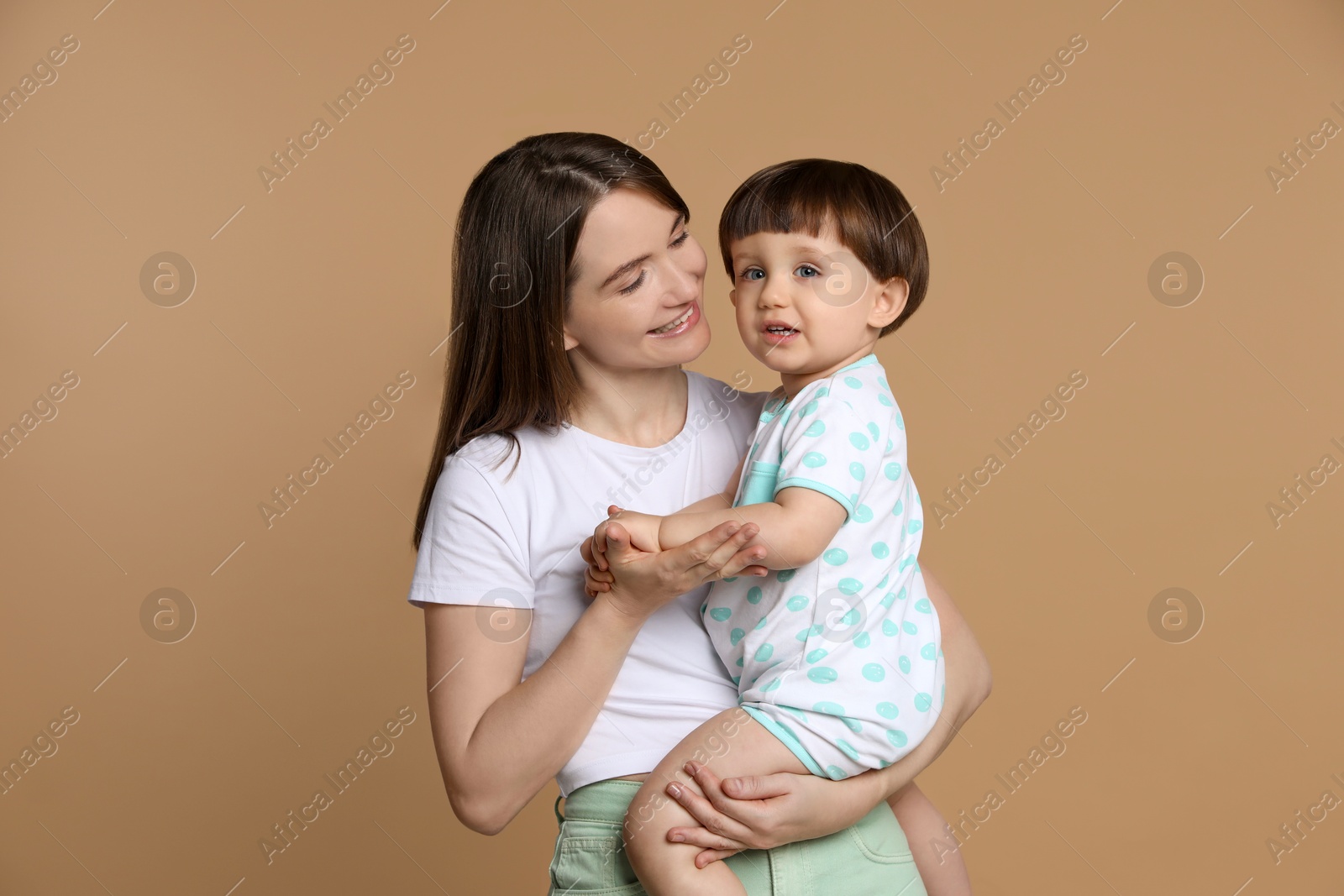 Photo of Family portrait of happy mother with her little son on beige background