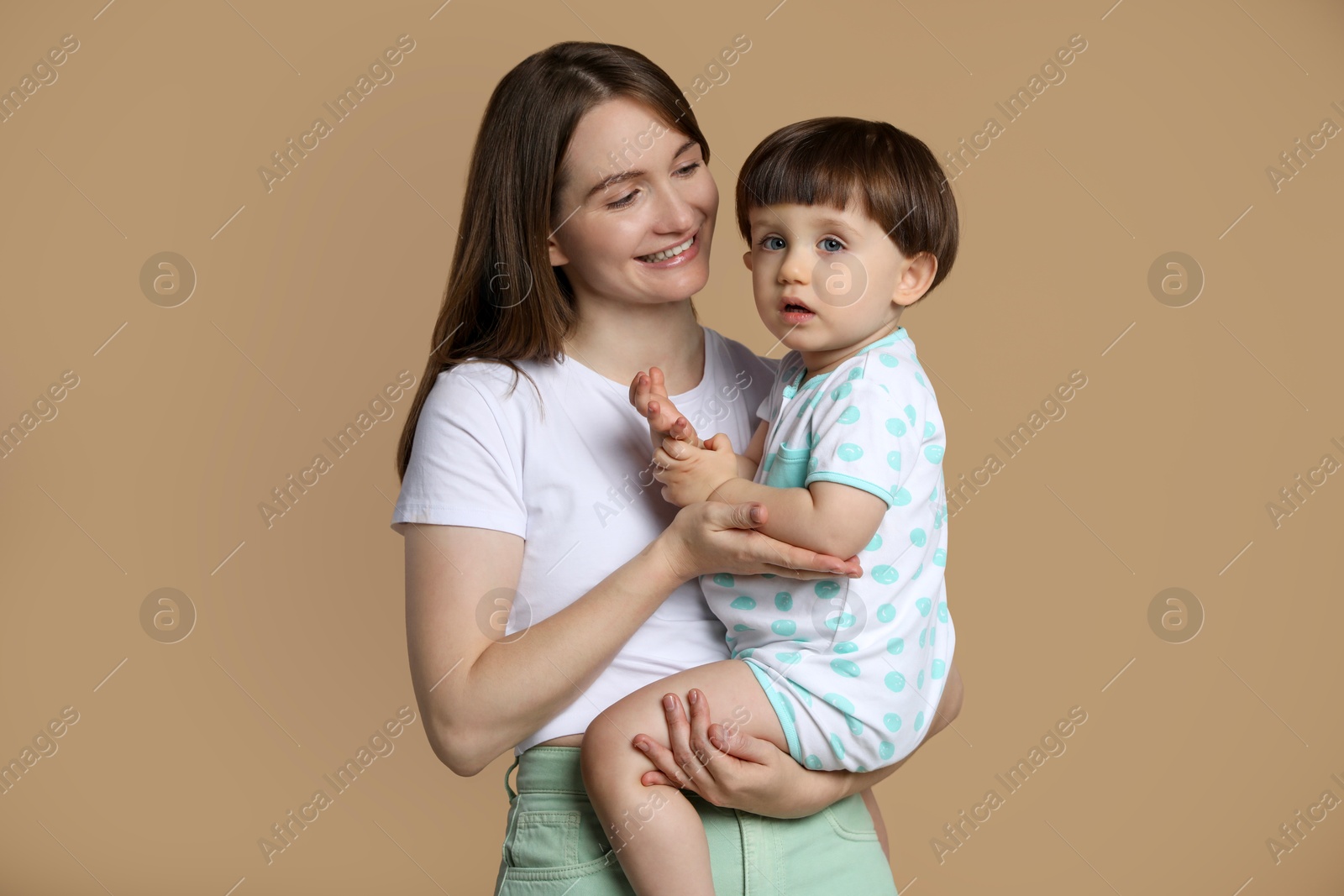 Photo of Family portrait of happy mother with her little son on beige background