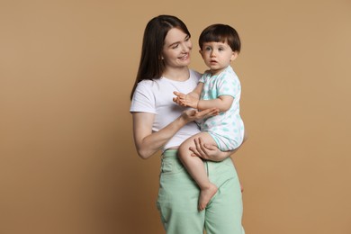 Photo of Family portrait of happy mother with her little son on beige background