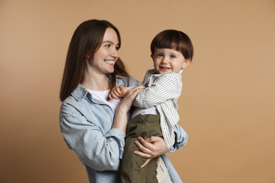 Photo of Family portrait of happy mother with her little son on beige background