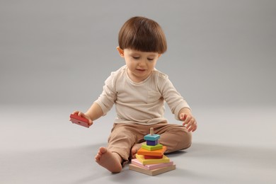 Photo of Cute little boy playing on grey background