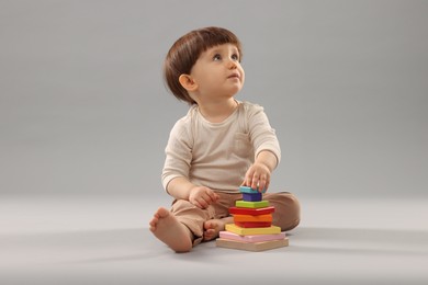 Photo of Cute little boy playing on grey background