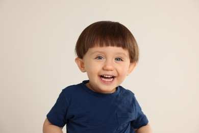 Photo of Portrait of happy little boy on light grey background