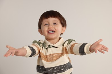 Photo of Happy little boy on light grey background