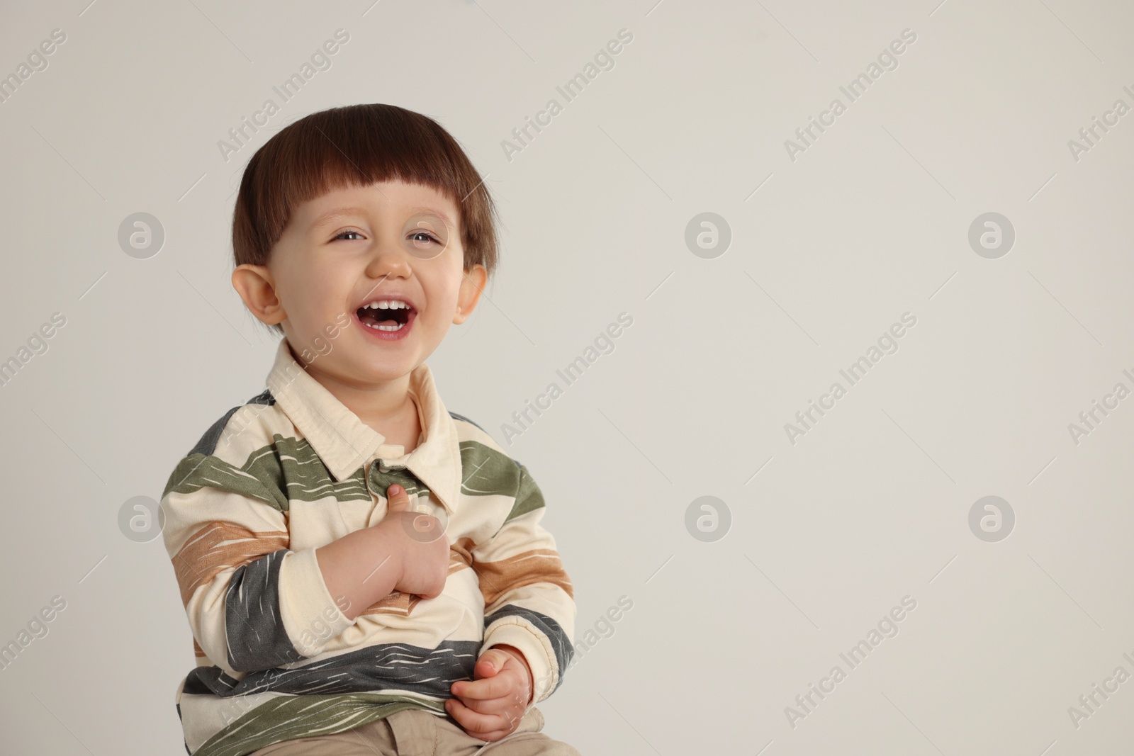 Photo of Emotional little boy on light grey background. Space for text