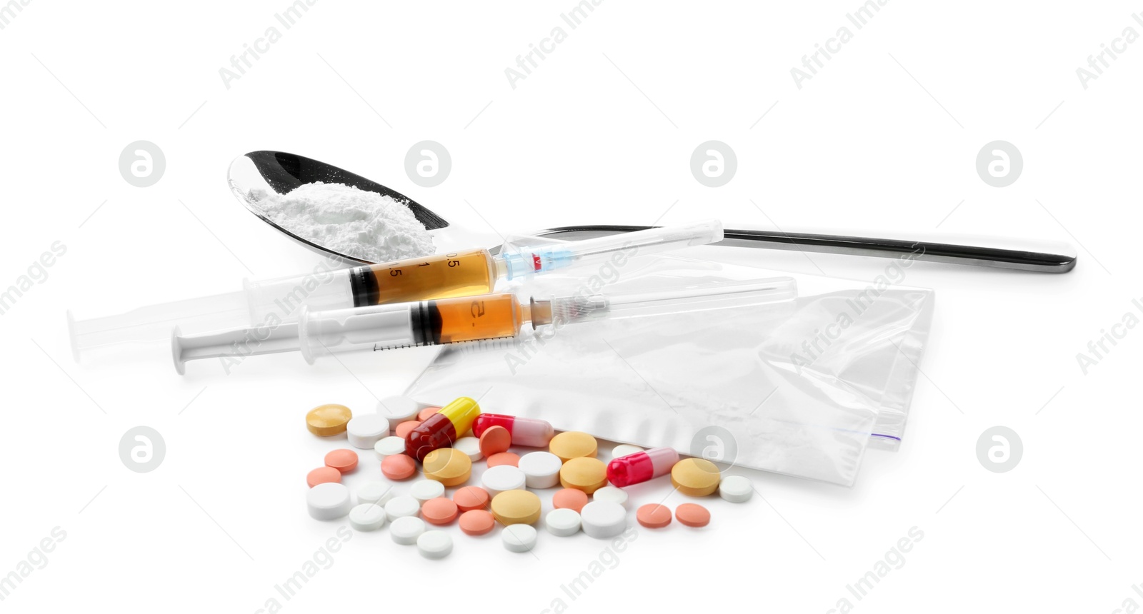 Photo of Drug addiction. Different pills, spoon with powder and syringes isolated on white