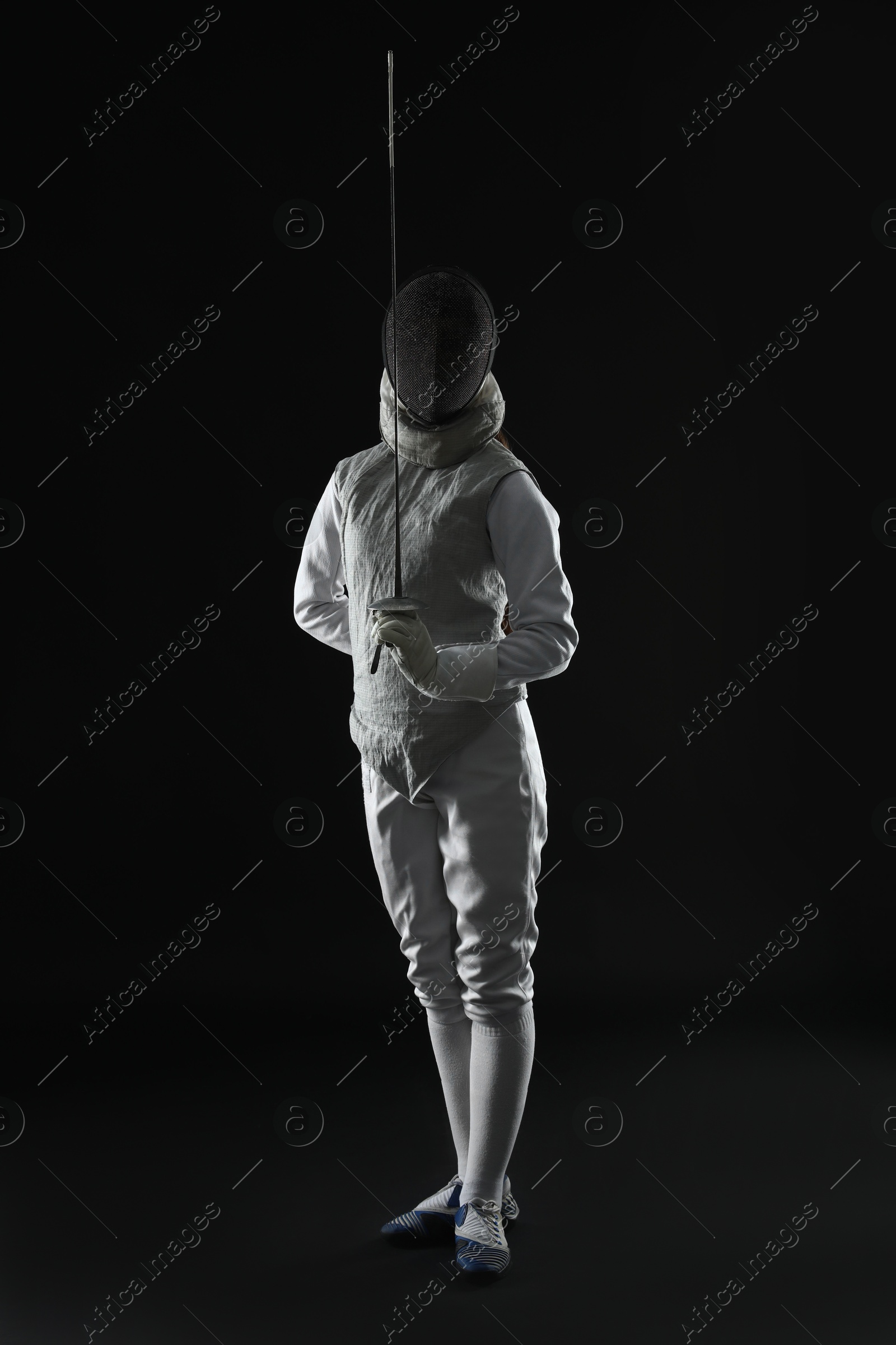 Photo of Fencer with epee on dark background. Combat sport