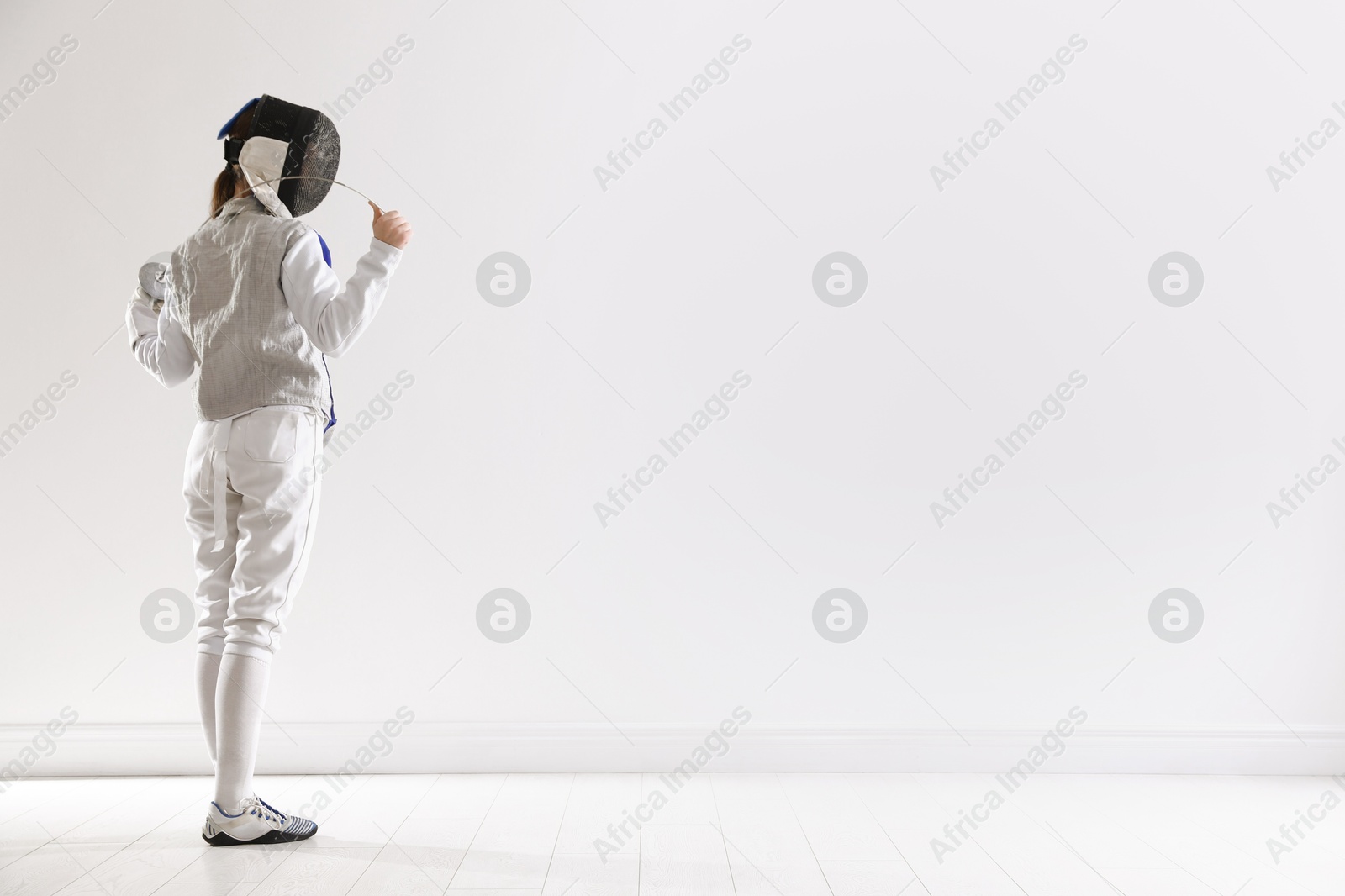 Photo of Fencer with epee indoors, space for text