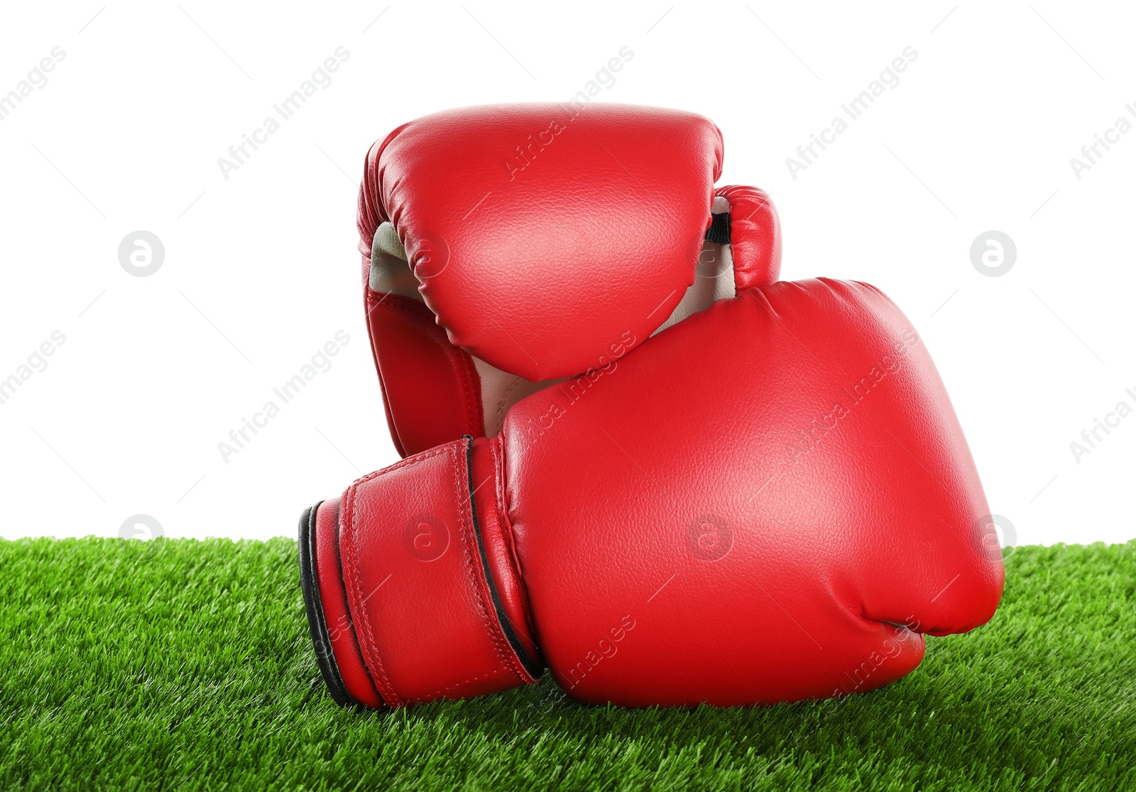 Photo of Boxing gloves on artificial grass isolated on white. Sport equipment