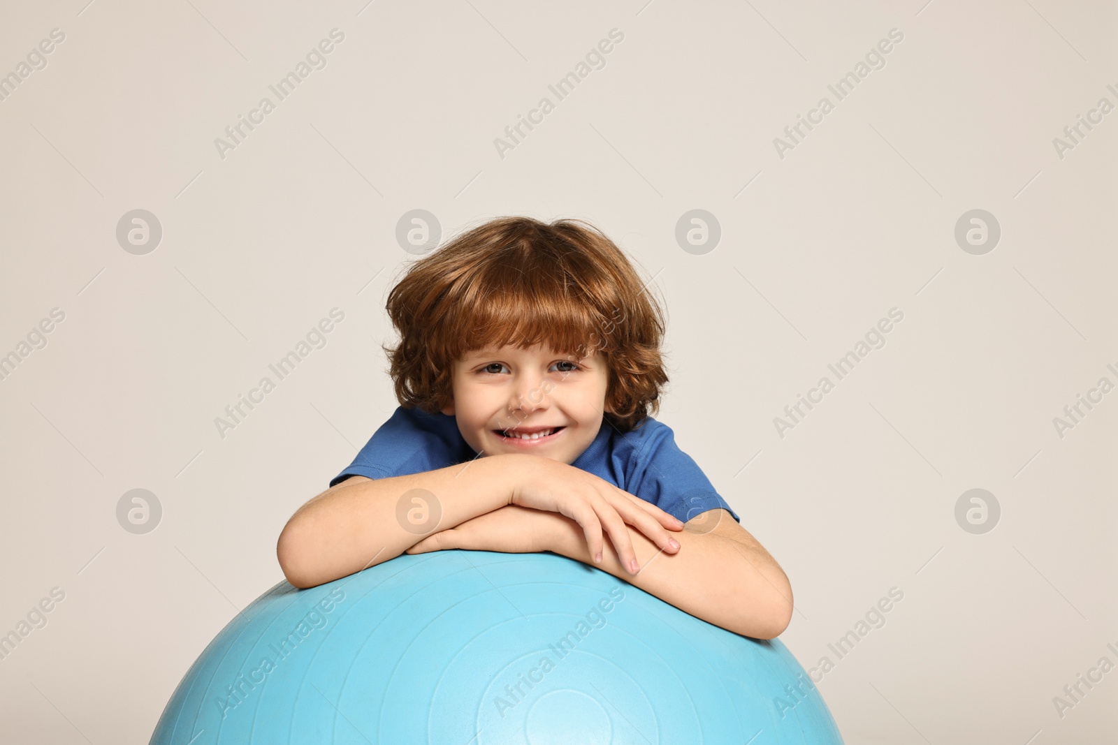 Photo of Little boy with fitness ball on light grey background