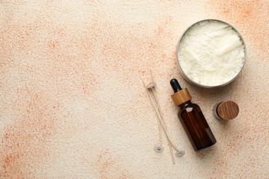 Photo of Making handmade candles. Soy wax in jar, essential oils and wicks on beige textured table, flat lay. Space for text