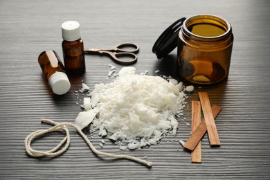 Making handmade candles. Soy wax, essential oils, twine, wooden wicks and jar on black textured table, flat lay