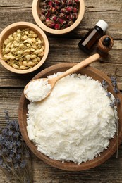 Photo of Soy wax in bowl and other different ingredients for making candles on wooden table, flat lay