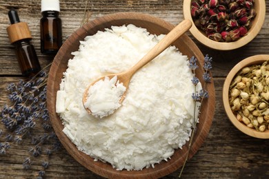 Photo of Soy wax in bowl and other different ingredients for making candles on wooden table, flat lay