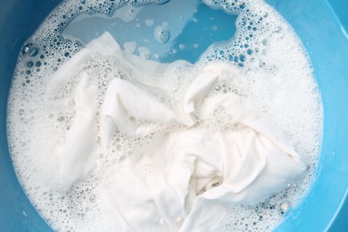 Photo of White clothes soaked in water before washing, top view