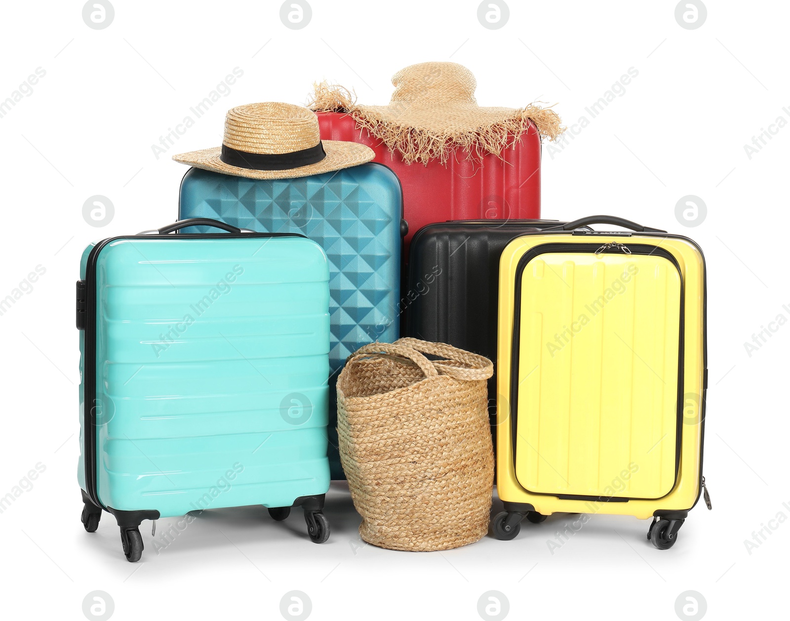 Photo of Many colorful suitcases, beach bag and straw hats isolated on white