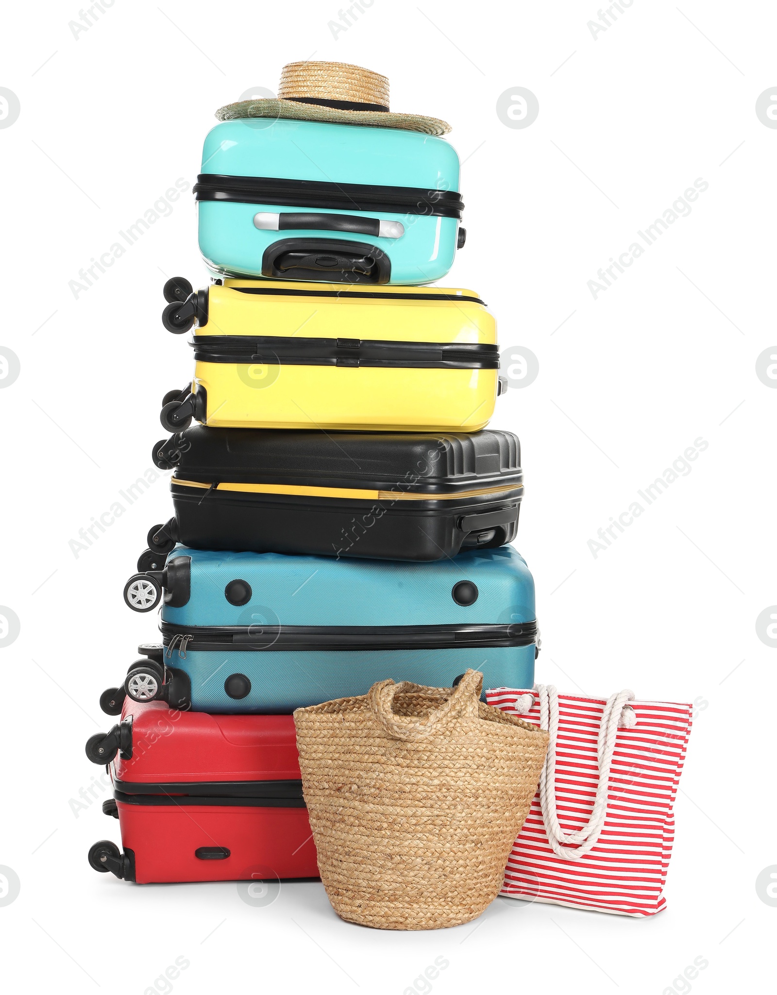 Photo of Stack of colorful suitcases, beach bags and straw hat isolated on white