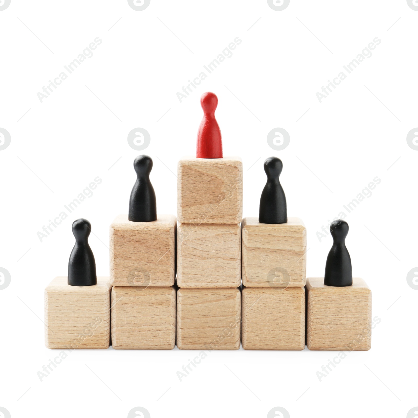 Photo of Human figures on wooden blocks, red one on top against white background. Competition concept