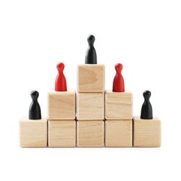 Photo of Human figures on wooden blocks, black one on top against white background. Competition concept