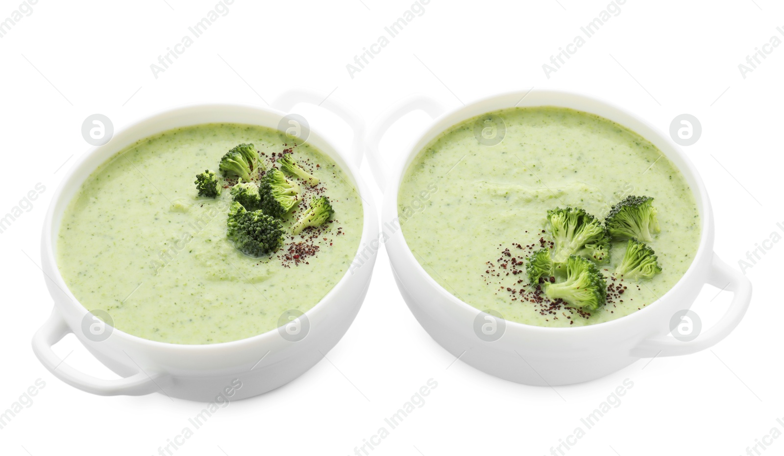 Photo of Delicious broccoli cream soup in bowls isolated on white