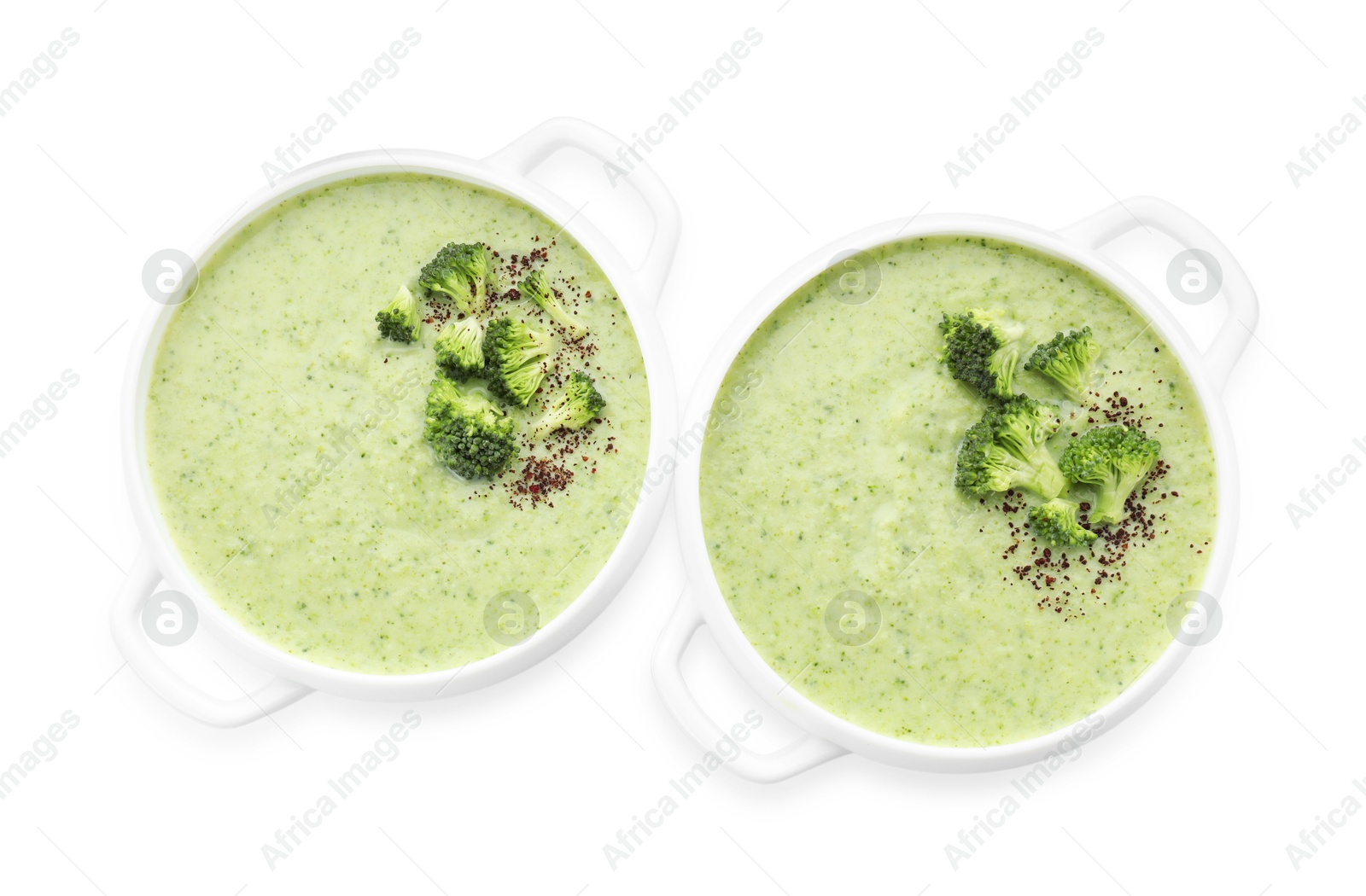 Photo of Delicious broccoli cream soup in bowls isolated on white, top view