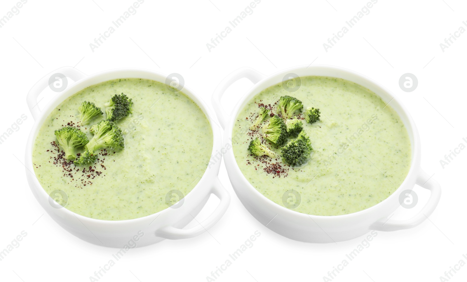 Photo of Delicious broccoli cream soup in bowls isolated on white