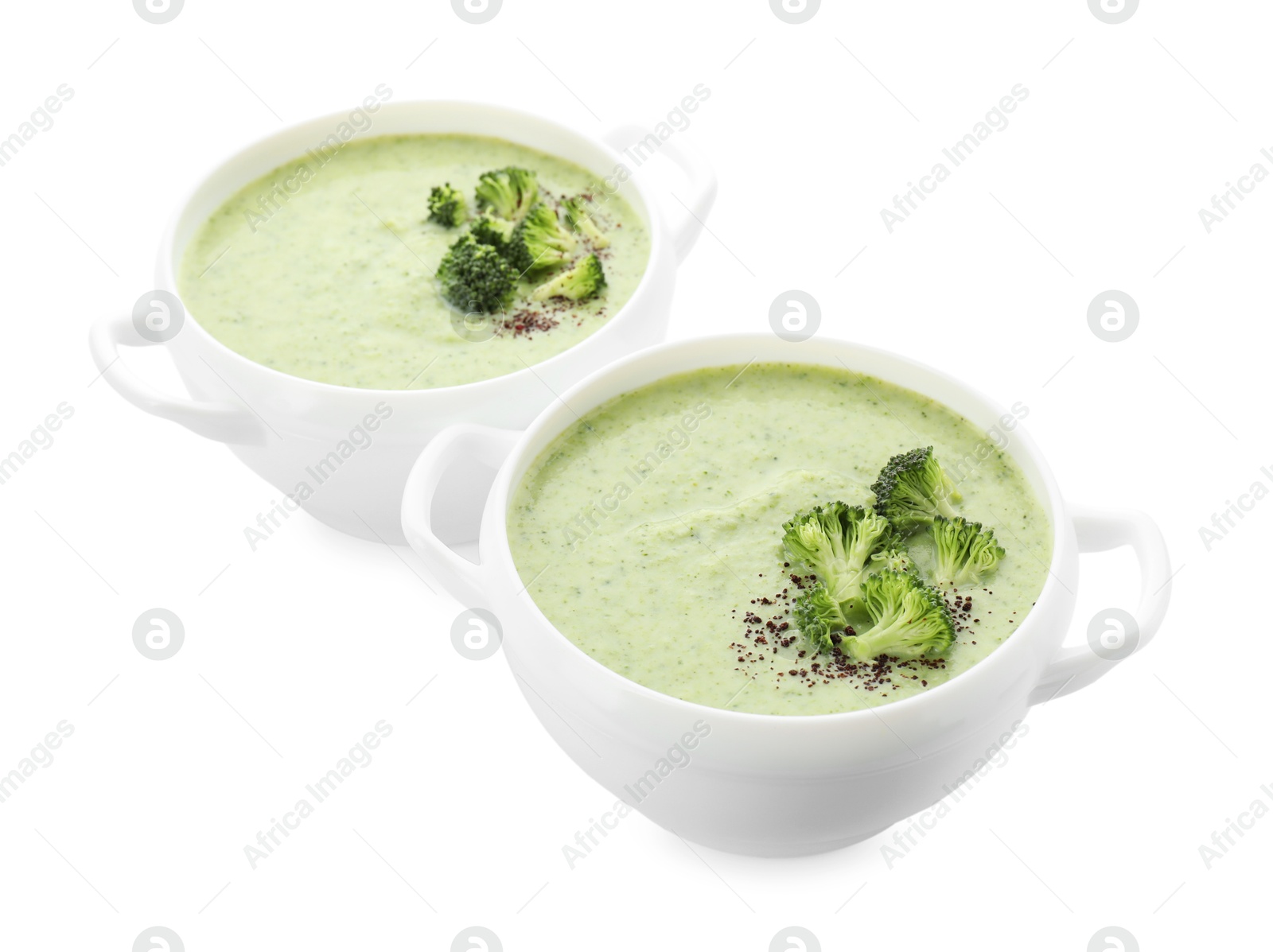 Photo of Delicious broccoli cream soup in bowls isolated on white