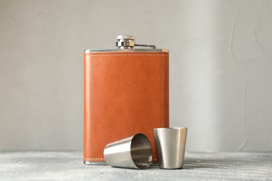 Photo of Hip flask and cups on grey table