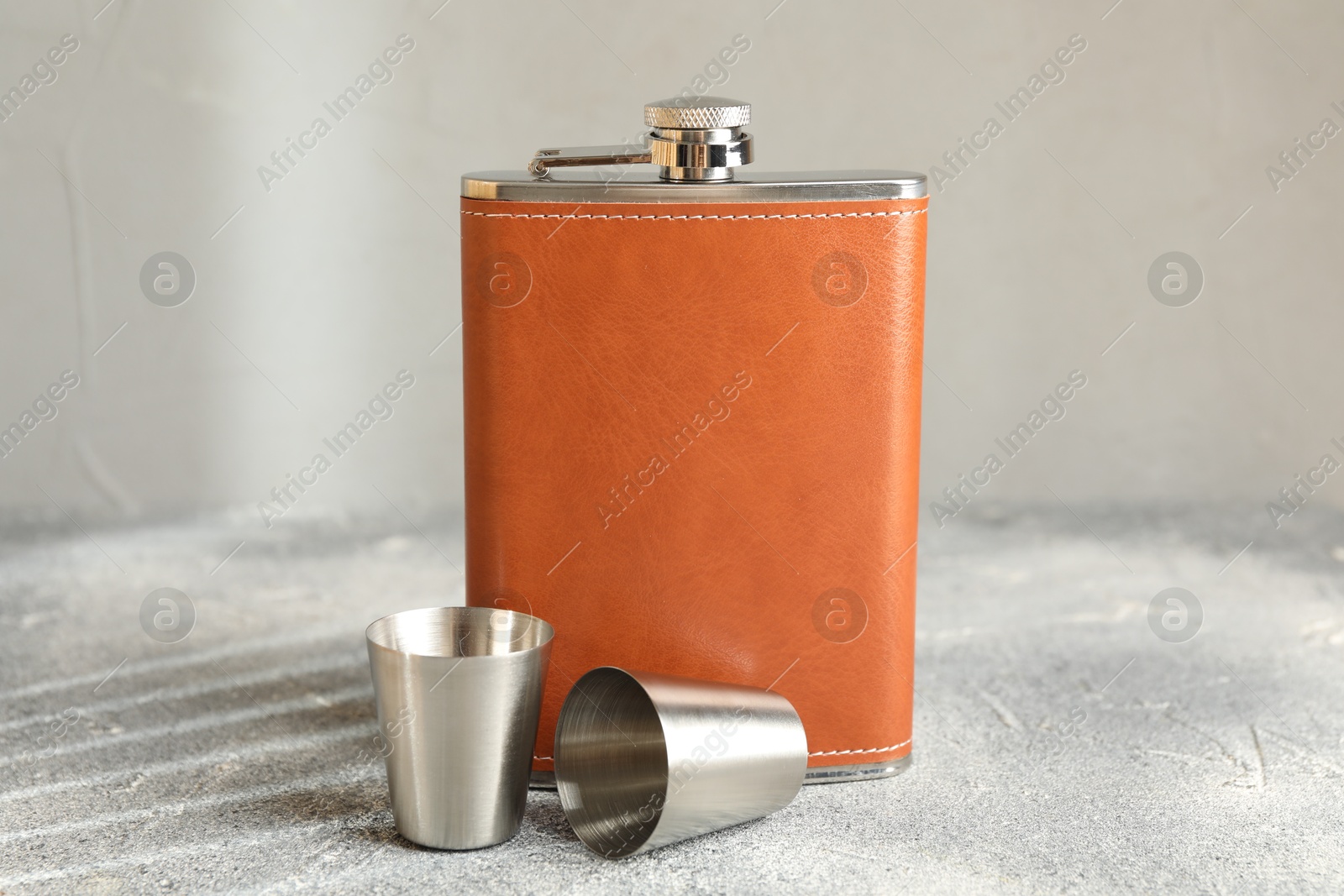 Photo of Hip flask and cups on grey table