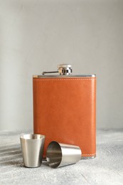 Photo of Hip flask and cups on grey table