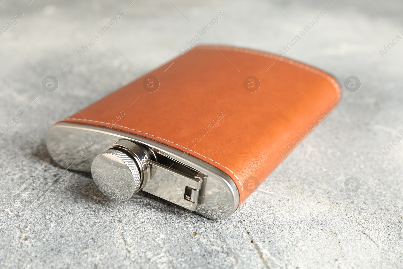 Photo of Hip flask on grey table, closeup view