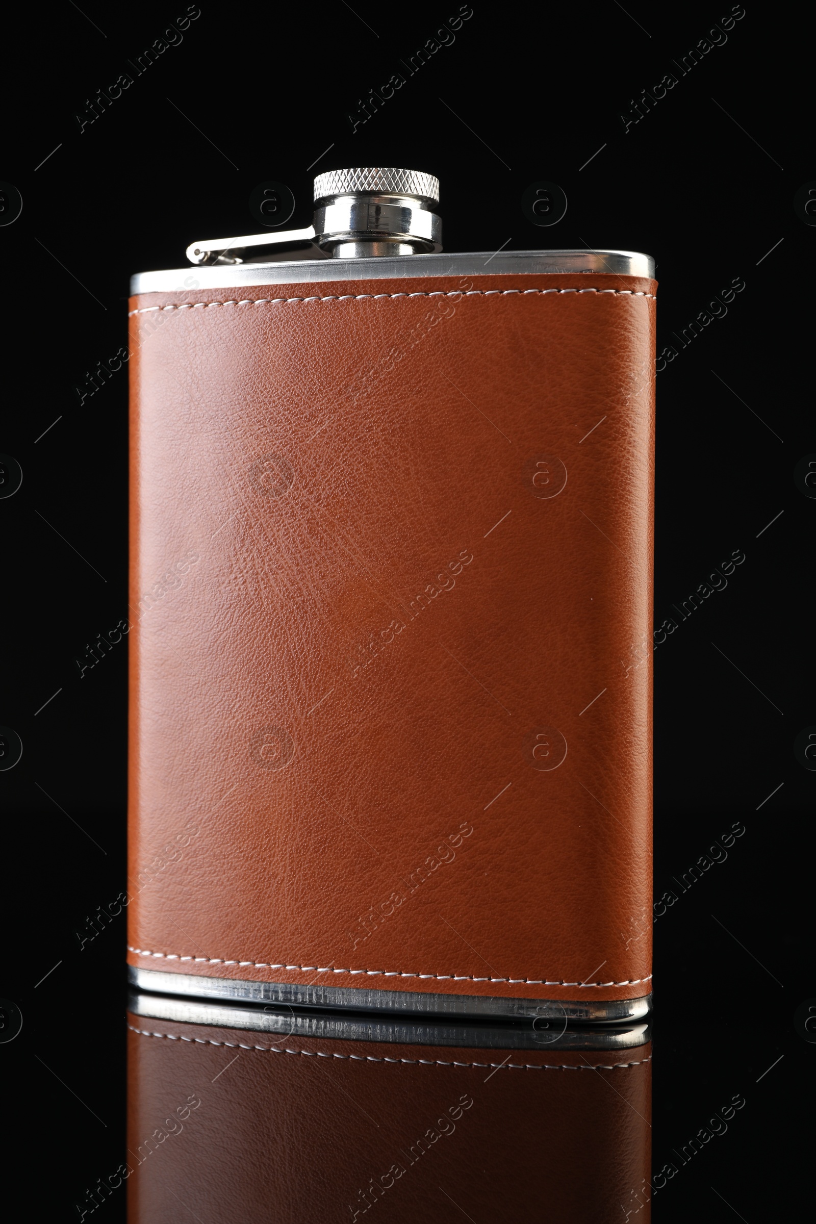 Photo of Leather hip flask on black mirror surface