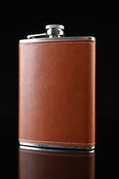 Photo of Leather hip flask on black mirror surface