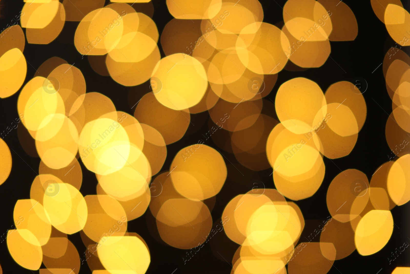 Photo of Blurred view of golden lights on dark background. Bokeh effect