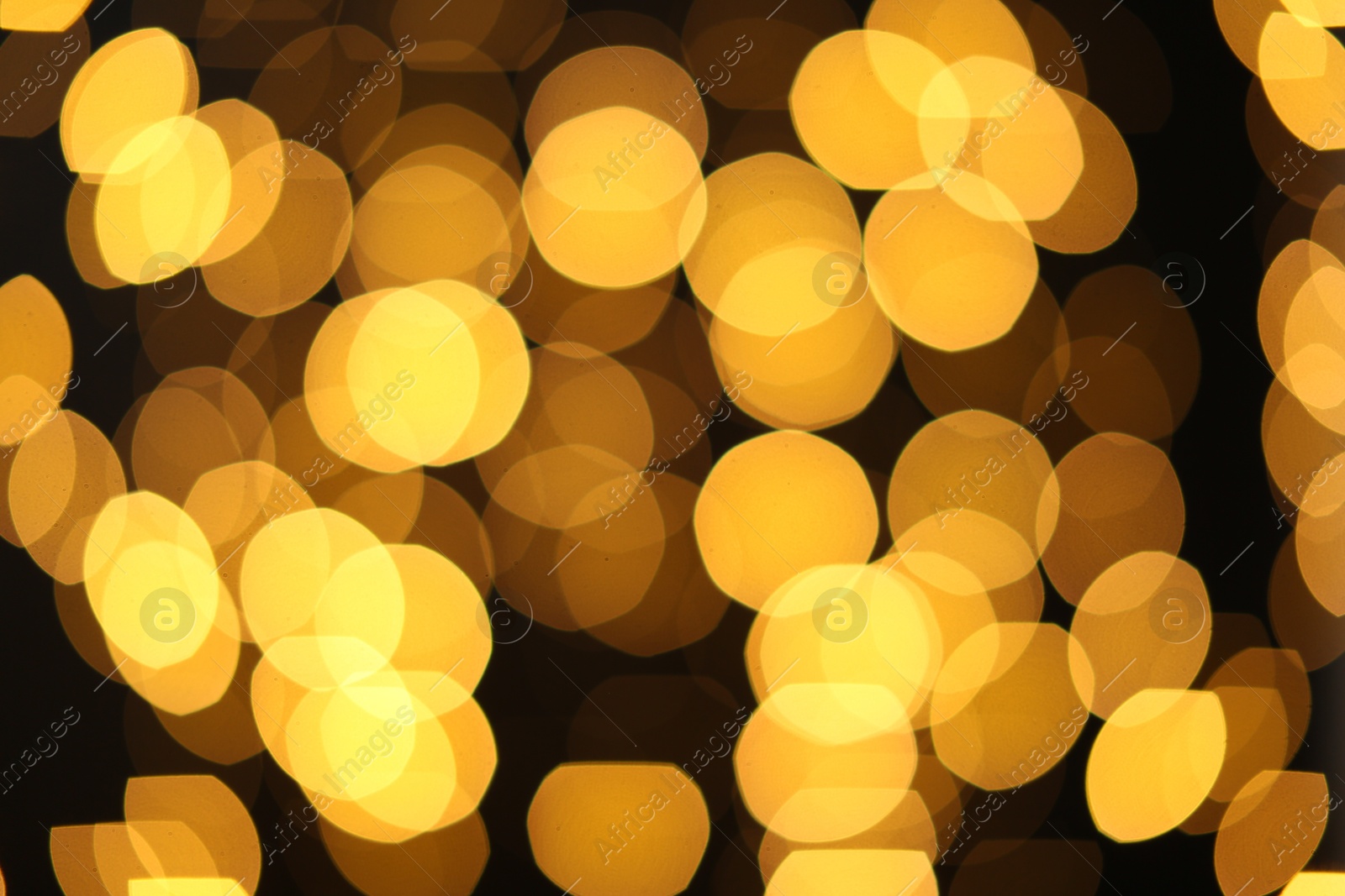 Photo of Blurred view of golden lights on dark background. Bokeh effect