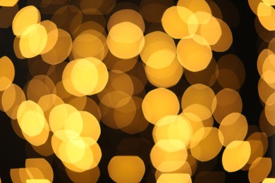 Photo of Blurred view of golden lights on dark background. Bokeh effect