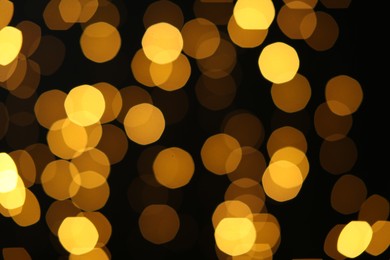 Photo of Blurred view of golden lights on black background. Bokeh effect