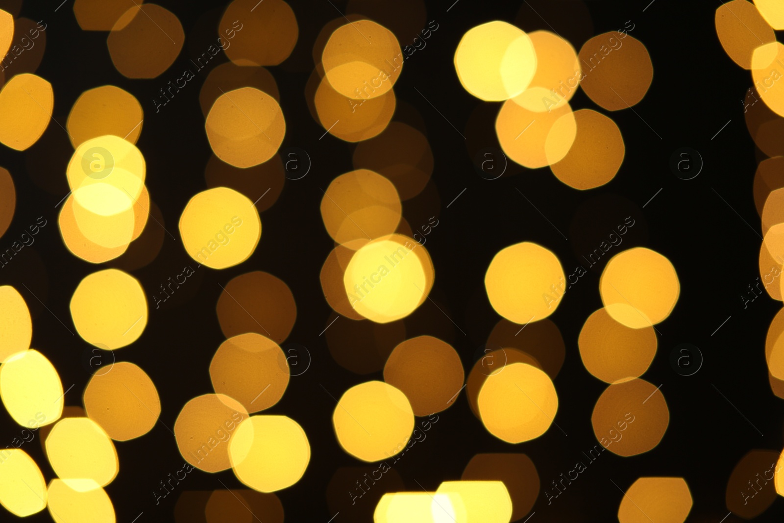 Photo of Blurred view of golden lights on black background. Bokeh effect