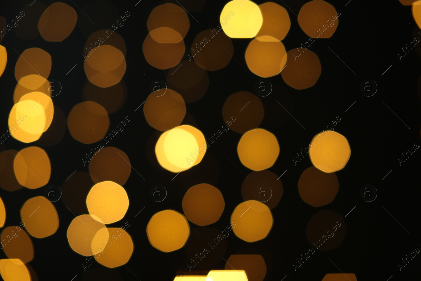 Photo of Blurred view of golden lights on black background. Bokeh effect