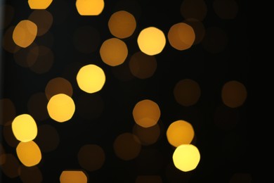 Photo of Blurred view of golden lights on black background. Bokeh effect